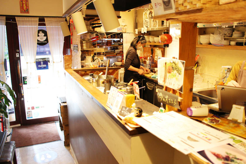 西公園商工連盟の「福岡のお粥カフェTeddy & Daddyテディ&ダディ」の店内です。カウンターの奥がキッチンとなっていて、店長さんが調理をしています。