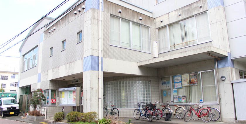 福岡市中央区の当仁公民館の外観です。コンクリート造りの建物です。駐輪スペースに自転車が何台かあります。