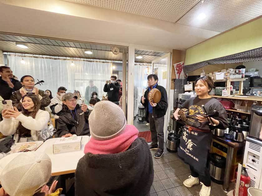 当仁校区地域住民と外国人交流事業　唐人町まち歩き　奄美大島のお店、まんでぃでの三線演奏会です